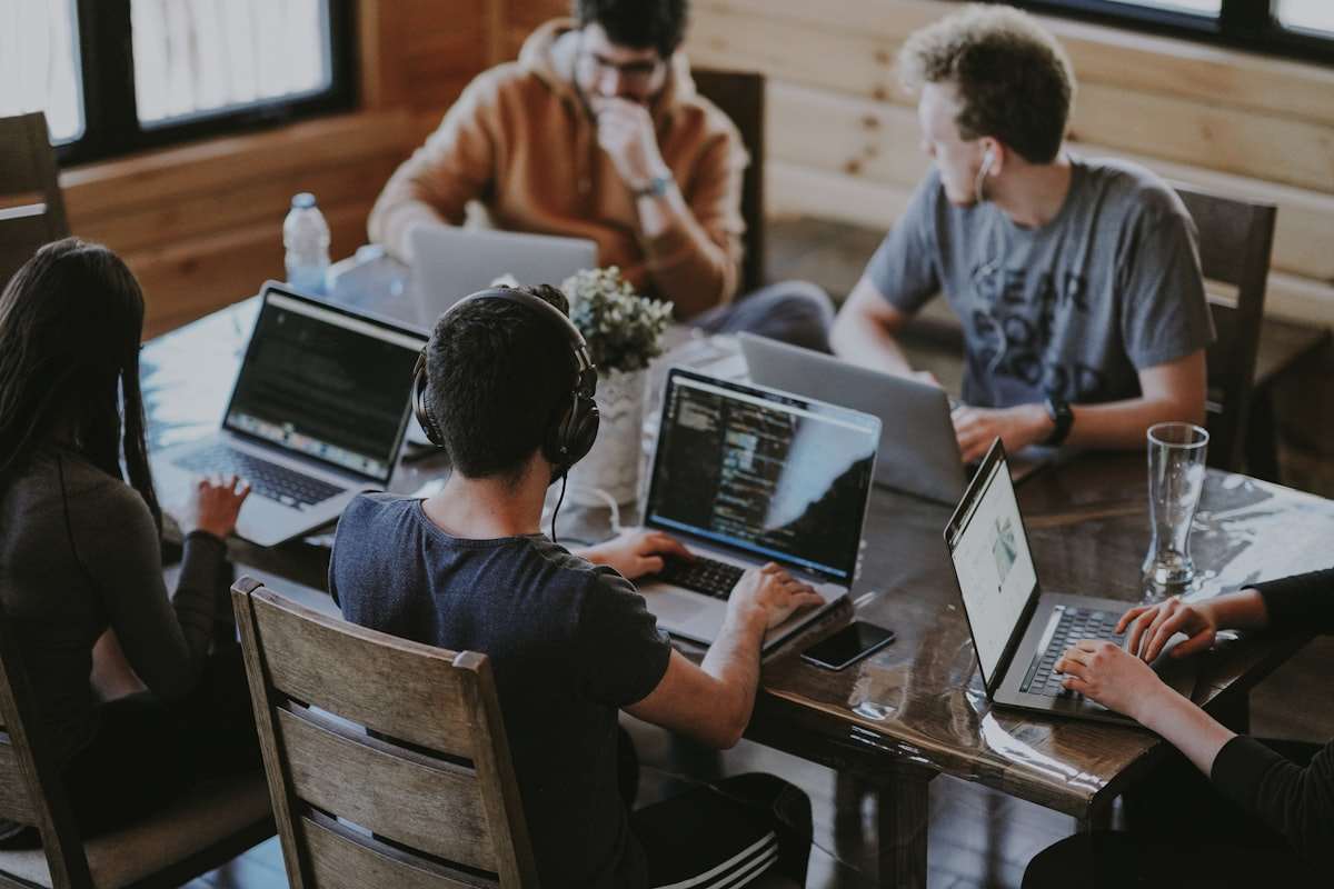 A team of specialists working together around laptops, a metaphor for a multi-agent pipeline